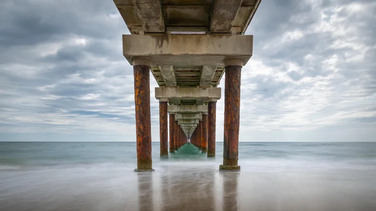 Long-exposure photograph beneath an ocean pier